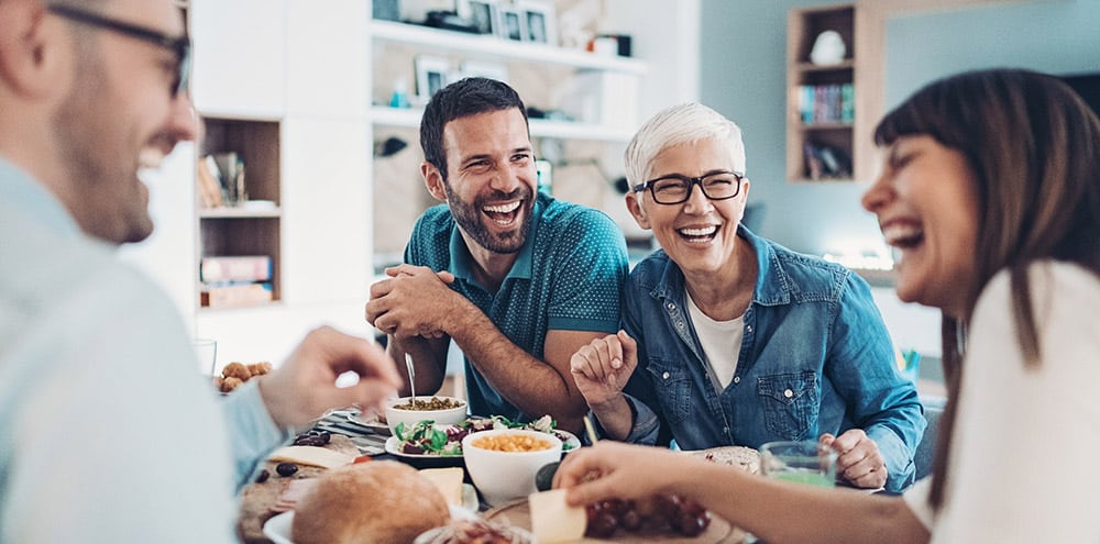 Family laughing at dining table