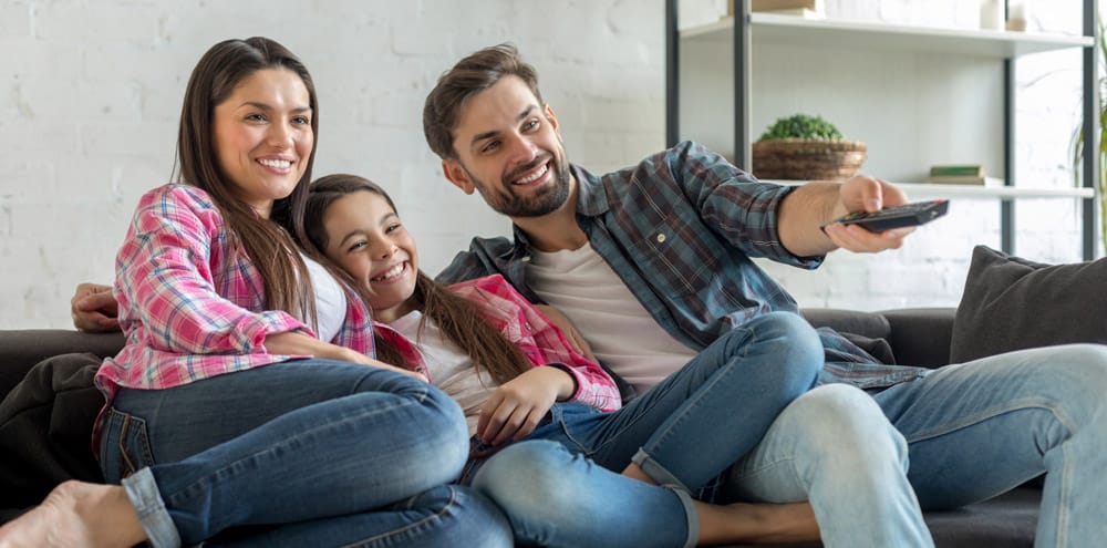 Family Relaxing In Air Conditioned Living Room