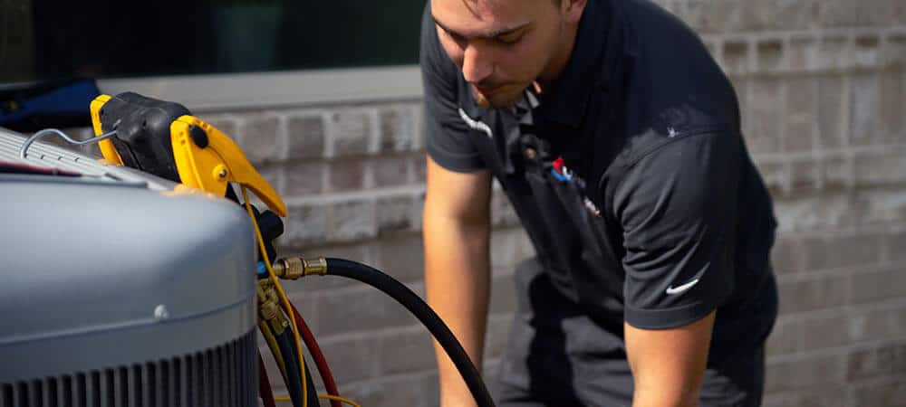 Lunsford Air Conditioning & Heating team member working on AC unit